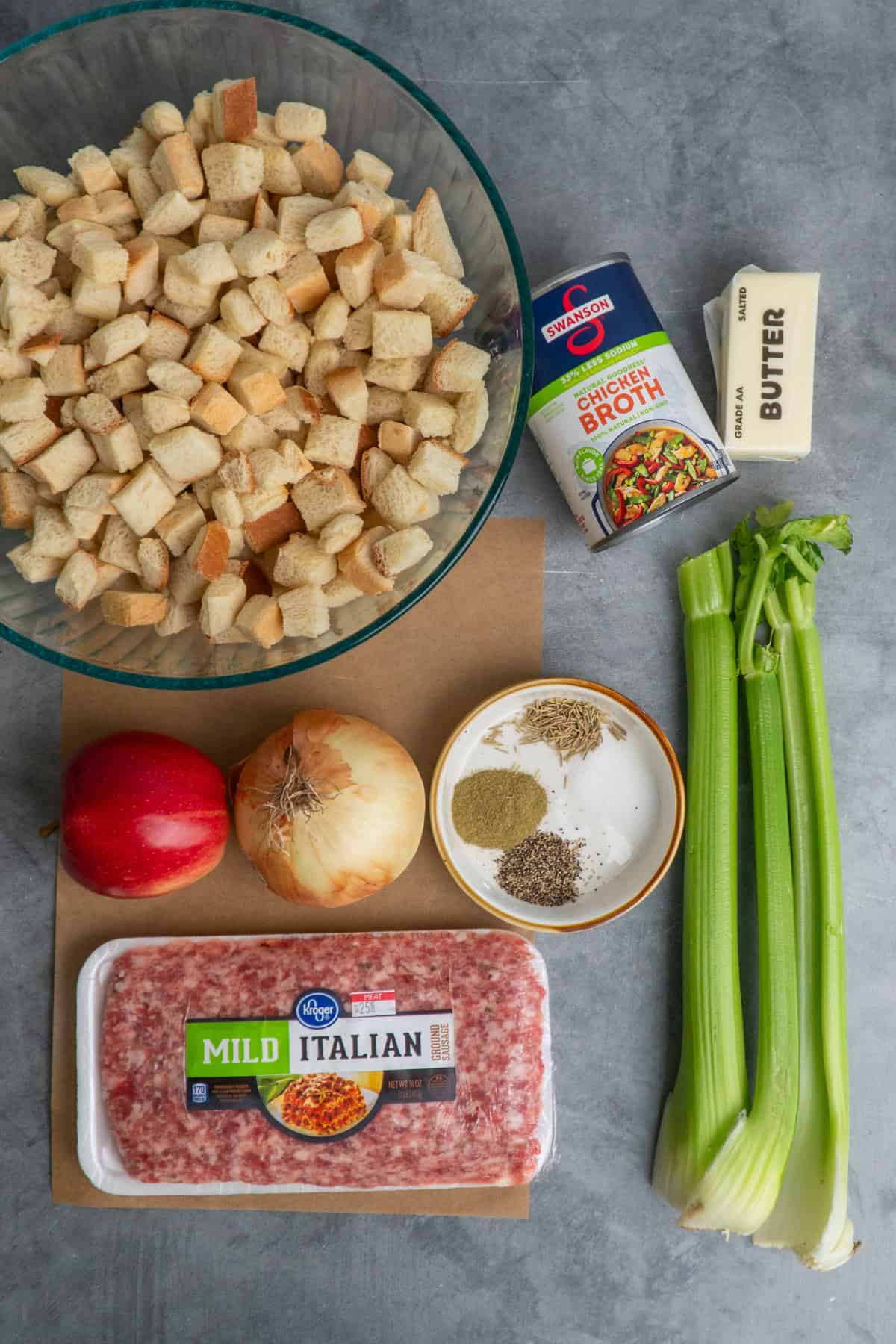 Ingredients to make sausage stuffing on a gray countertop.