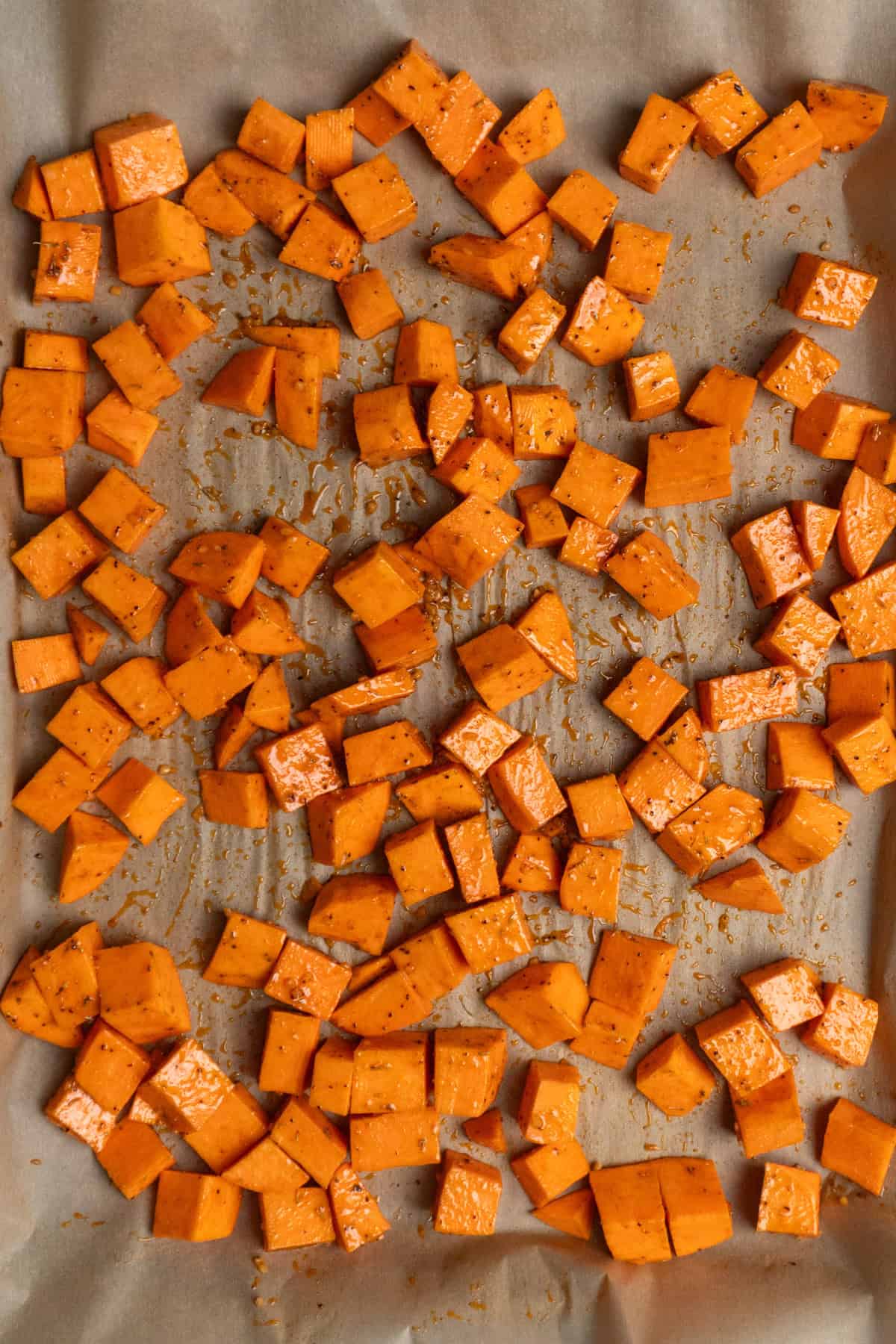 Chopped sweet potatoes coated in Dijon marinade ready to bake.