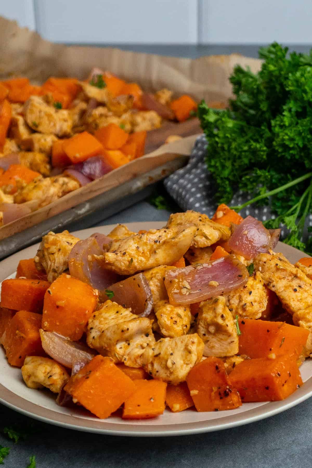 Sheet pan chicken and sweet potatoes on a plate.