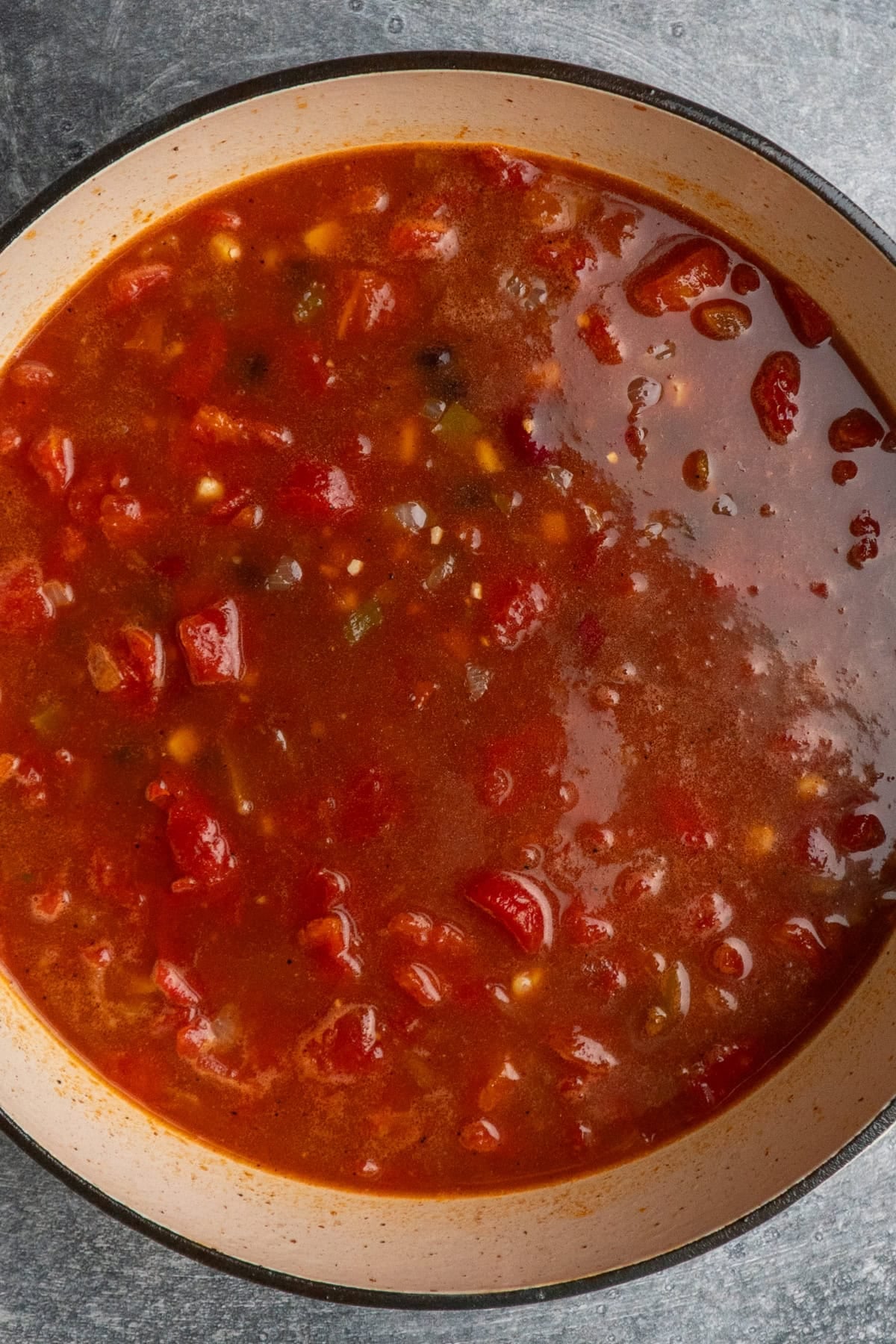 Diced tomatoes, onions, beans, corn, water and seasonings added to the Dutch oven.
