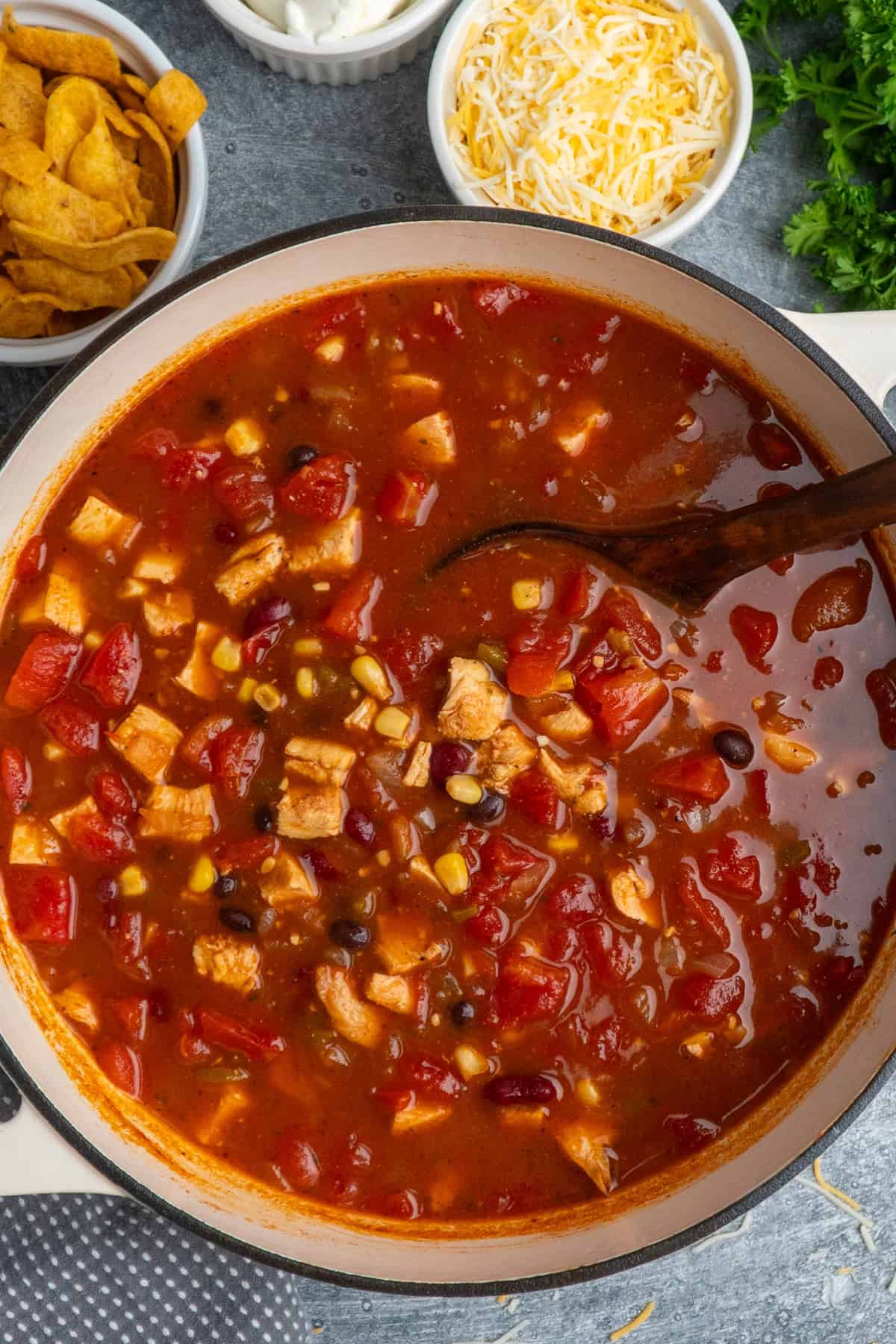 Chicken taco soup in a Dutch oven with a wooden ladle ready to be served.