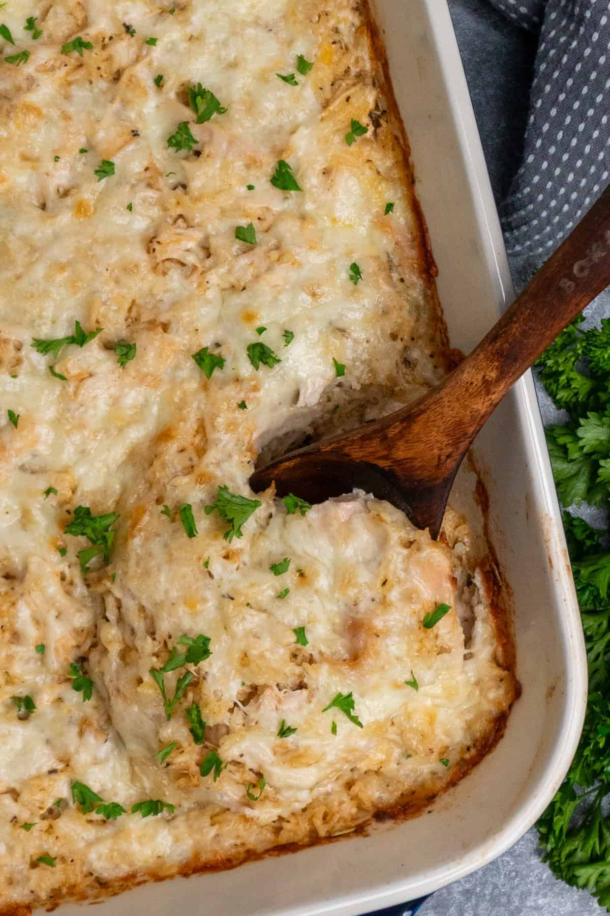 Chicken and rice casserole with a wooden spoon in it and ready to serve.