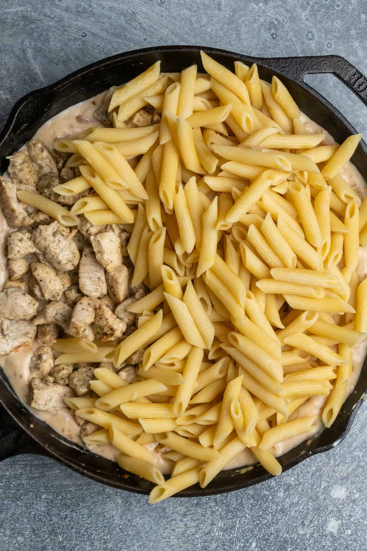 Cooked pasta and chicken added to the sauce.