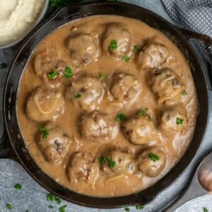 Meatballs and gravy in a cast iron skillet ready to be served.