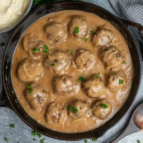 Meatballs and gravy in a cast iron skillet ready to be served.