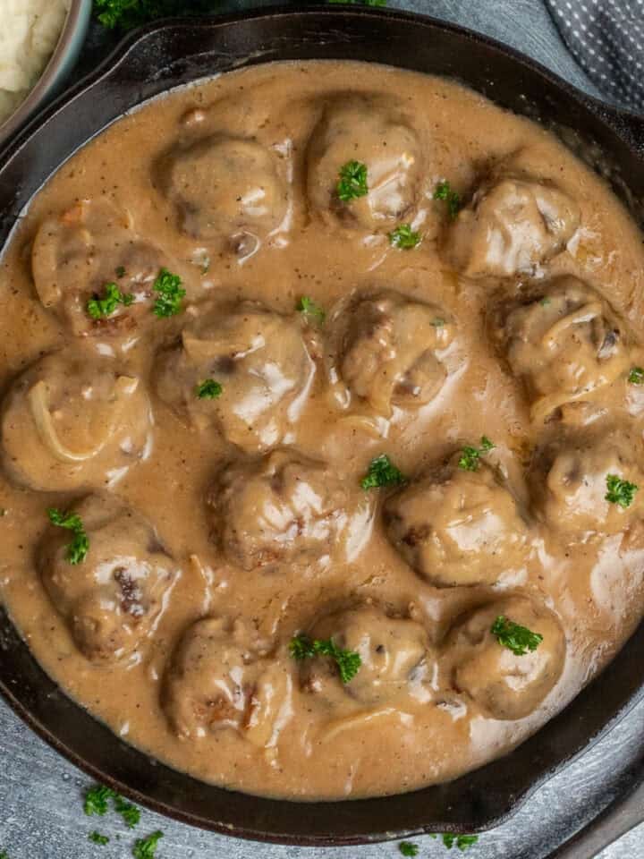 Meatballs and gravy in a cast iron skillet ready to be served.