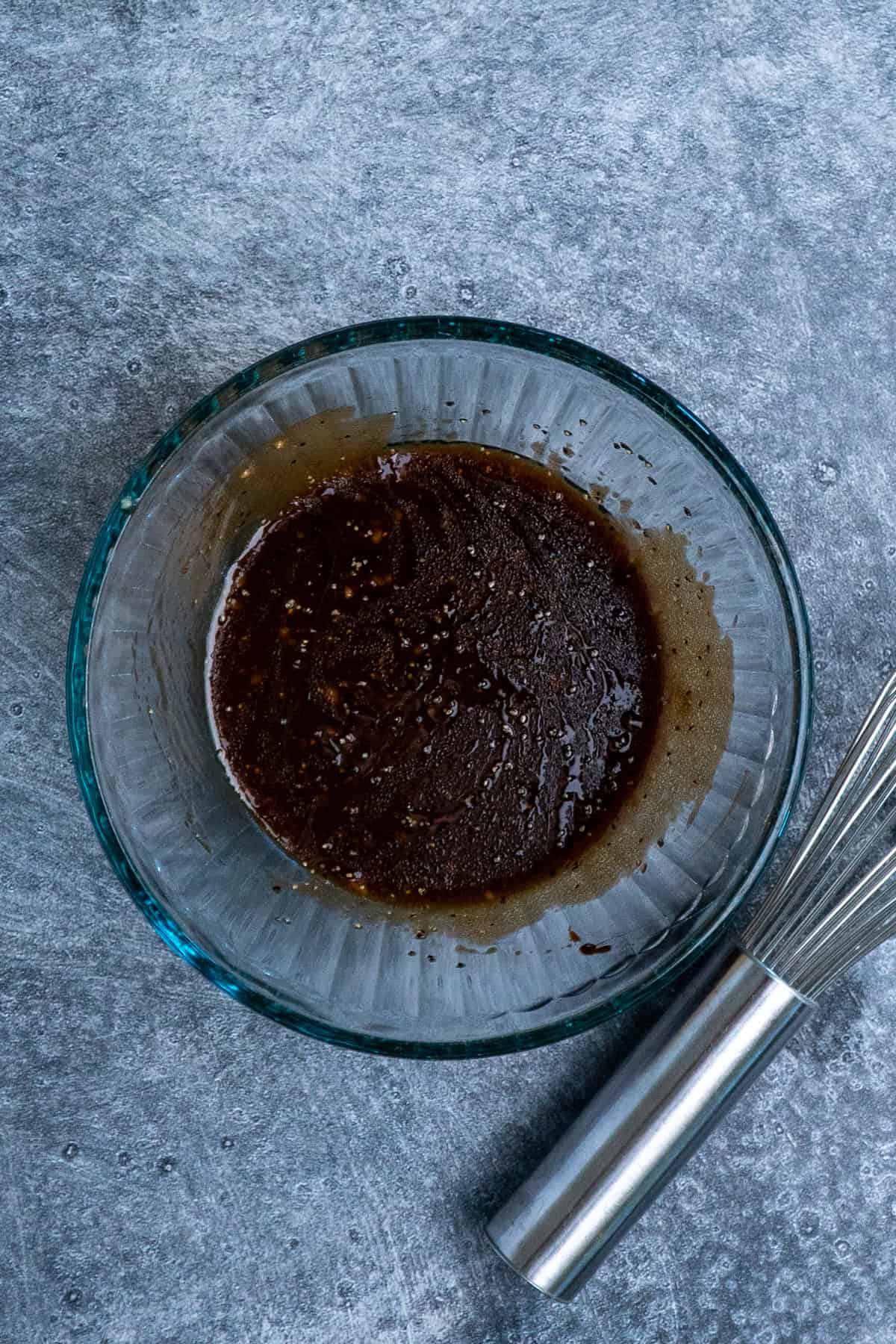 Honey balsamic dressing whisked together in a clear bowl.