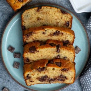 Four Slices of chocolate chunk banana bread on a plate.