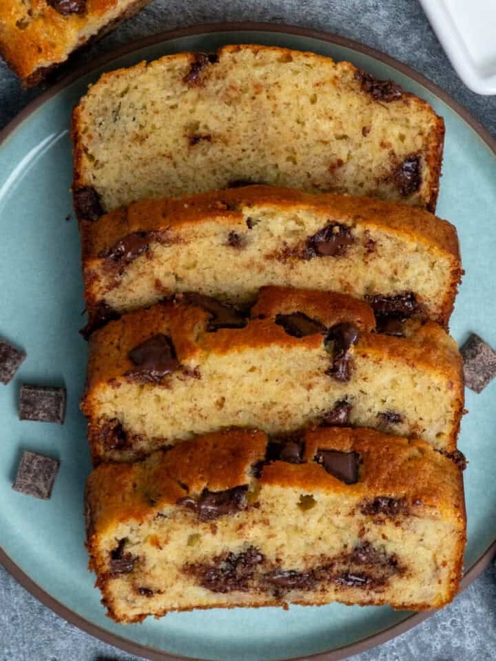 Four Slices of chocolate chunk banana bread on a plate.