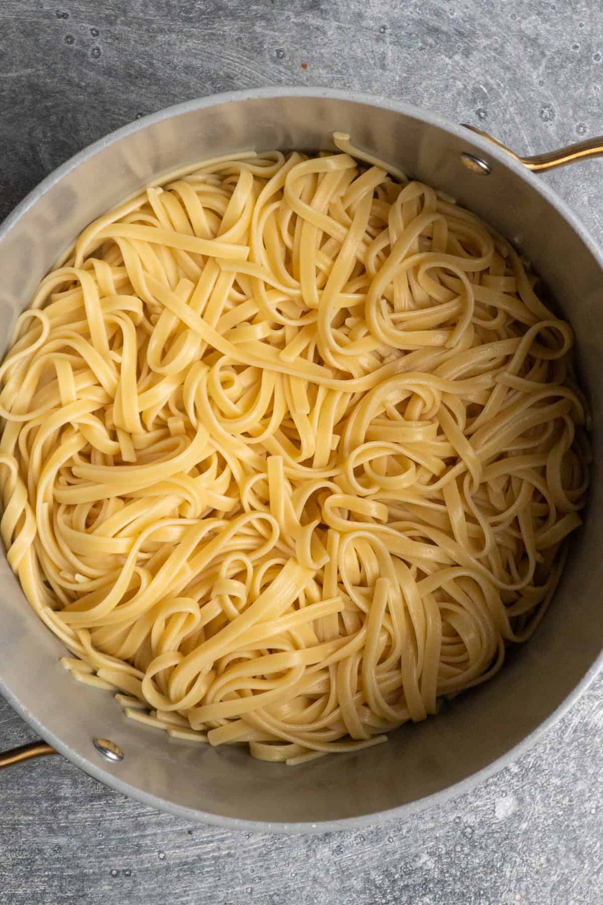 Pasta cooked and drained in a pot.