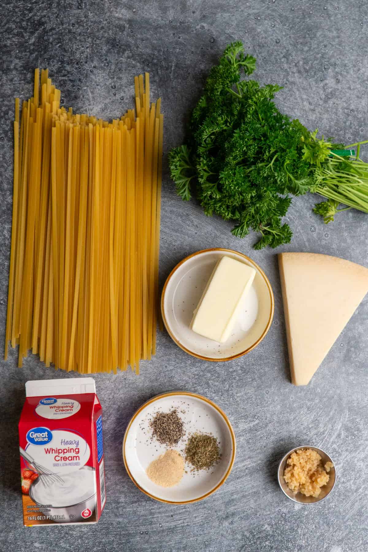 Ingredients to make this alfredo dish on a table.