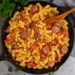 Rotel pasta in a cast iron skillet with a wooden spoon ready to be served.