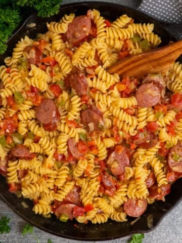 Rotel pasta in a cast iron skillet with a wooden spoon ready to be served.