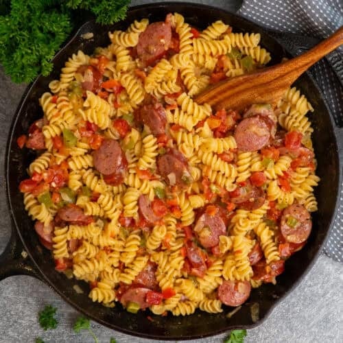 Rotel pasta in a cast iron skillet with a wooden spoon ready to be served.