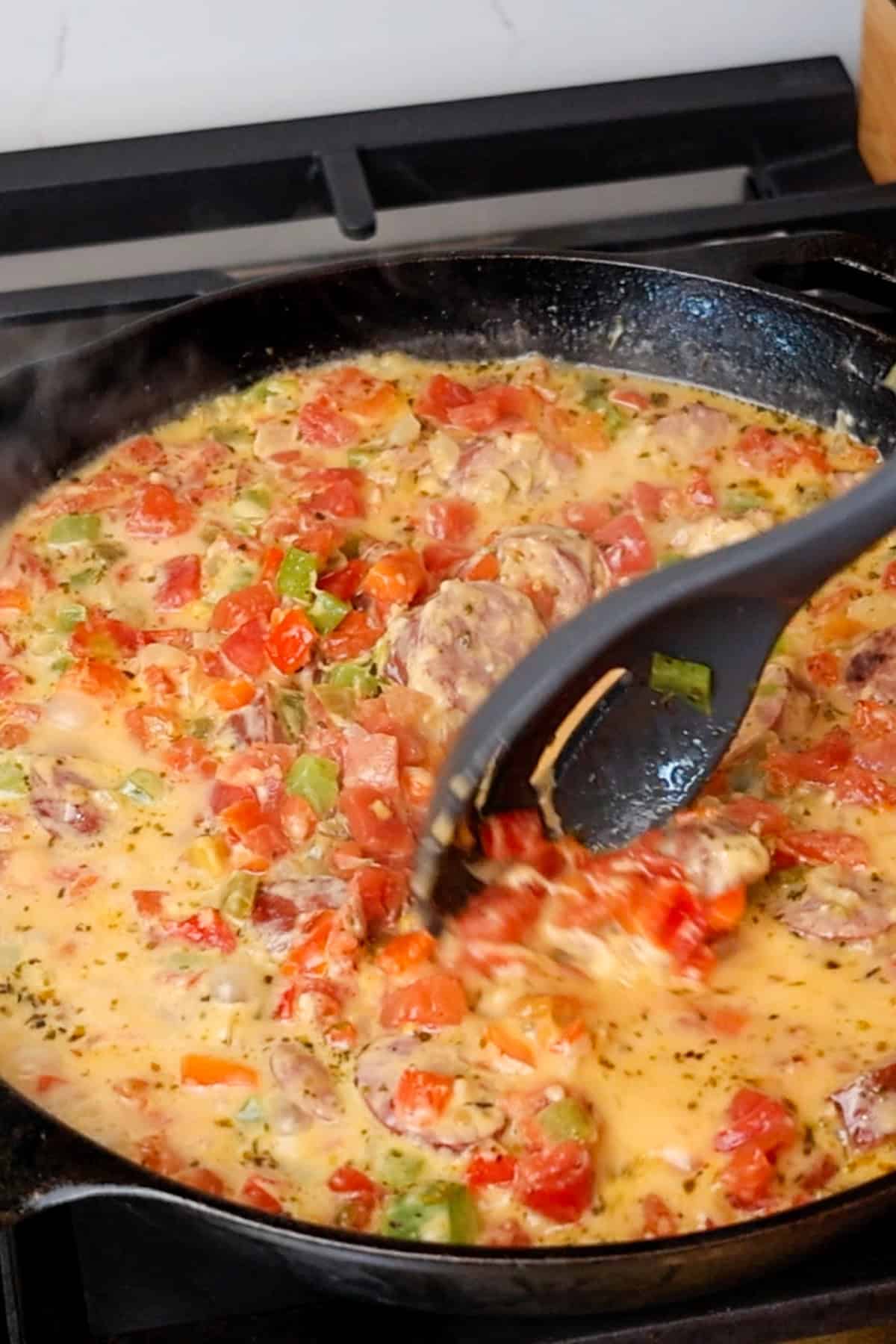 Seasonings, milk, and cheese mixed into the veggies and sausage.