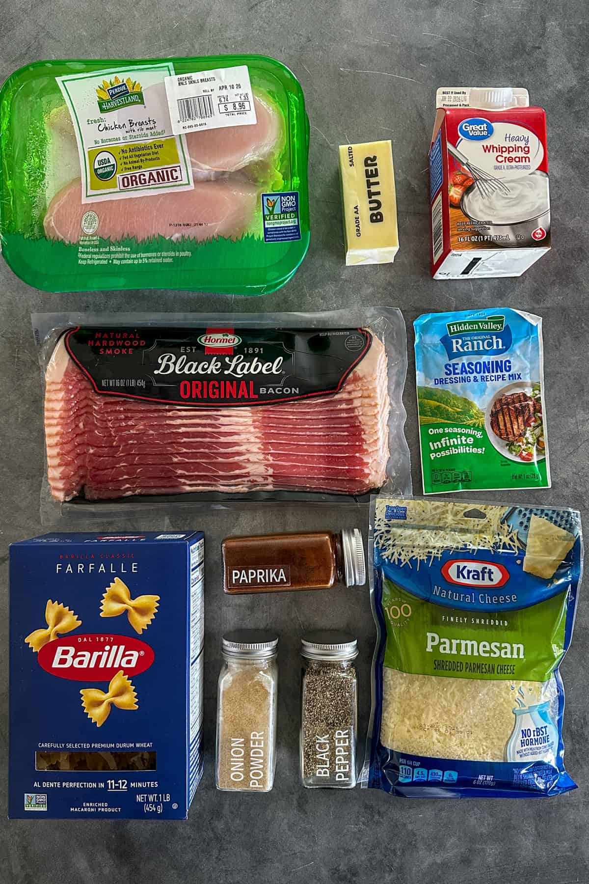Ingredients to make chicken bacon ranch pasta on a gray stone countertop.