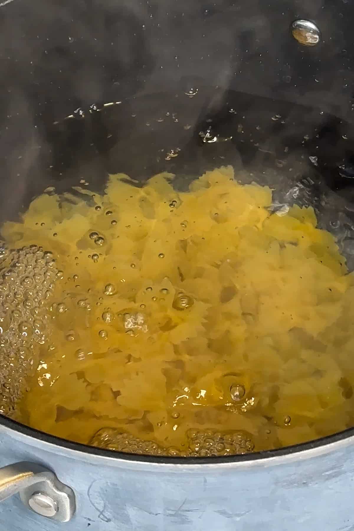 Bowtie pasta being cooking in a pot of water.