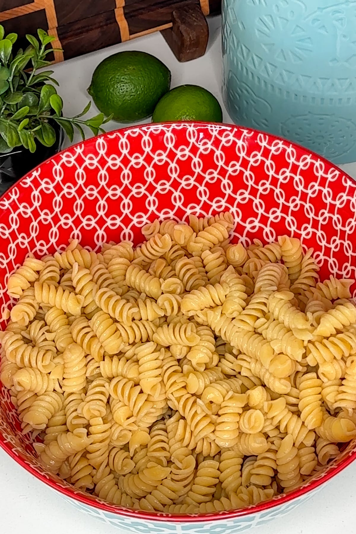 Cooked pasta in a red colorful bowl.
