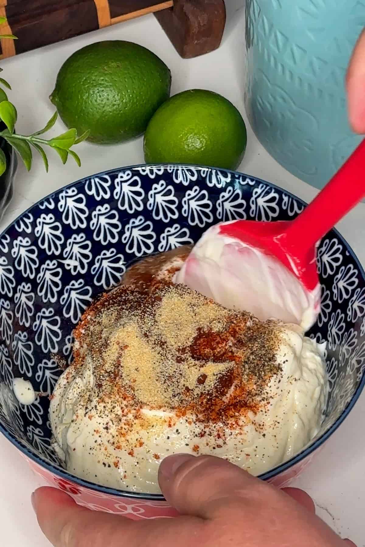 Mayonnaise, sour cream, and seasonings in a bowl ready to be mixed together. 