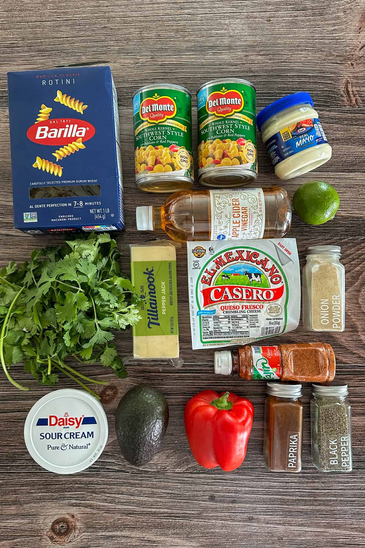 Ingredients to make Mexican street corn pasta salad on a wooden table.