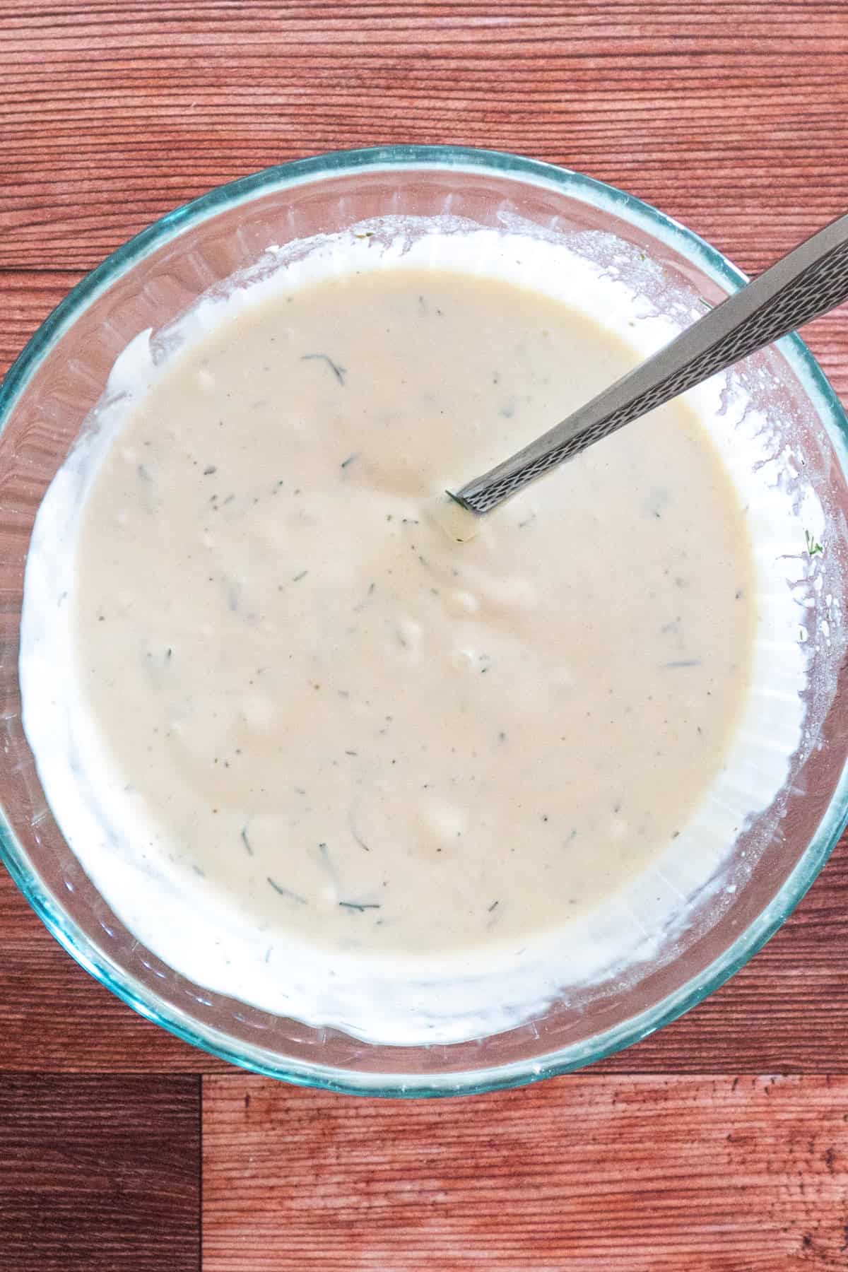 Dressing ingredients mixed together in a clear bowl.