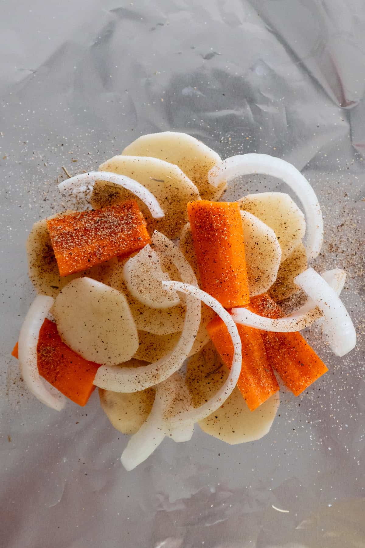 Slice potatoes, carrots and onions on a piece of foil and seasoned.