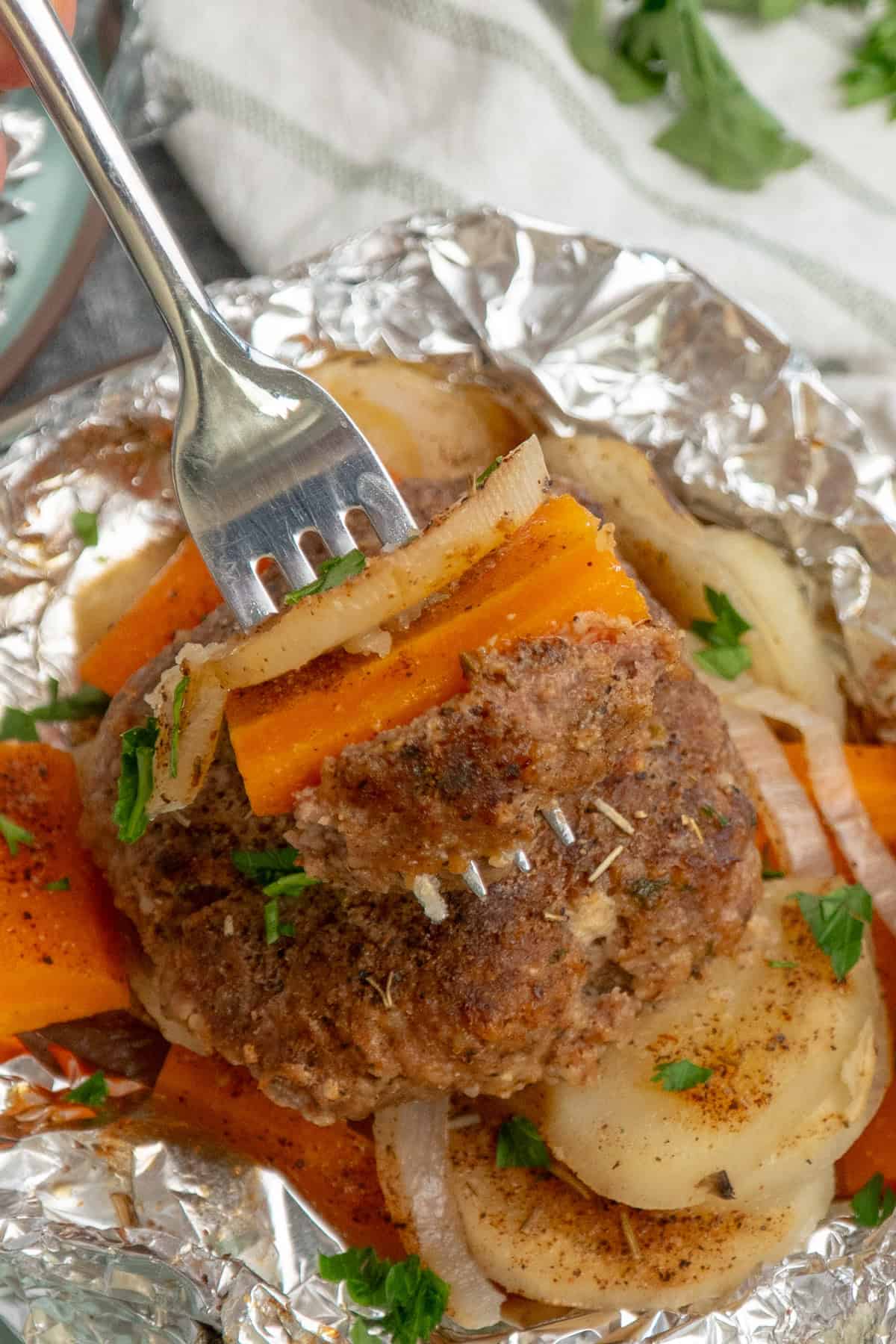A fork holding a bite of a hobo dinner.