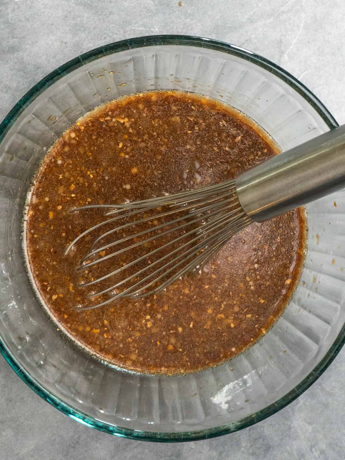 Teriyaki sauce ingredients whisked together in a clear bowl.